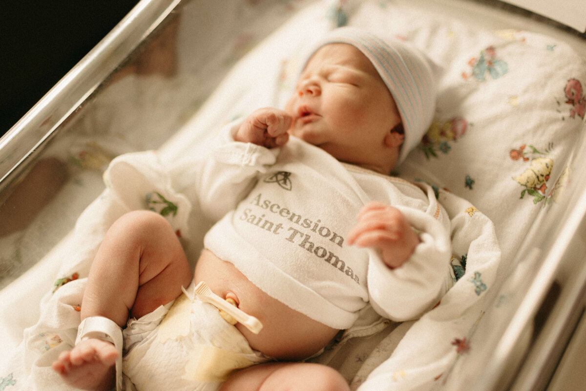 Newborn stretching arms wide in swaddle during Nashville Fresh 48 photos.