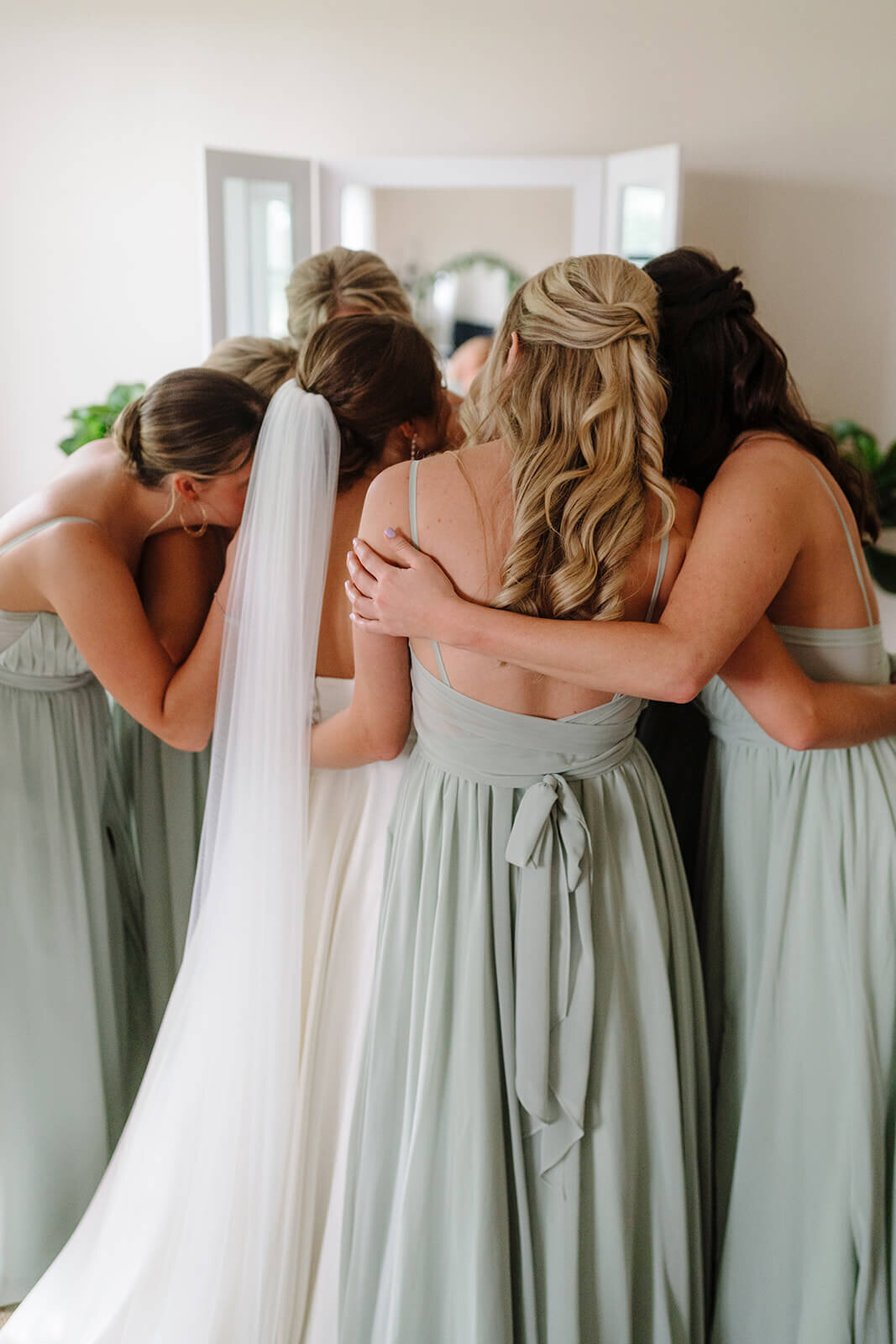 Bride and bridesmaids hugging at Oswego wedding, NY
