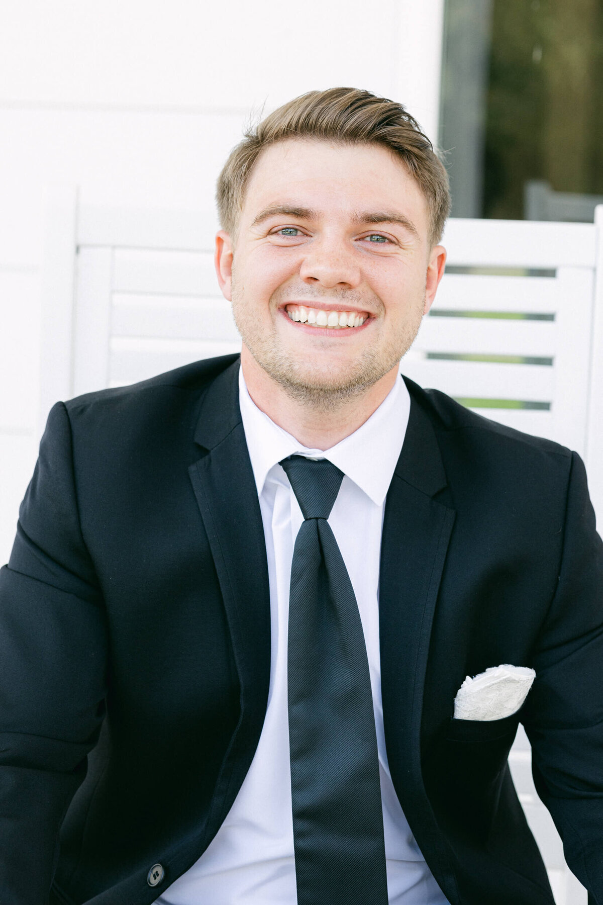 A wedding photo of the groom smiling for the camera