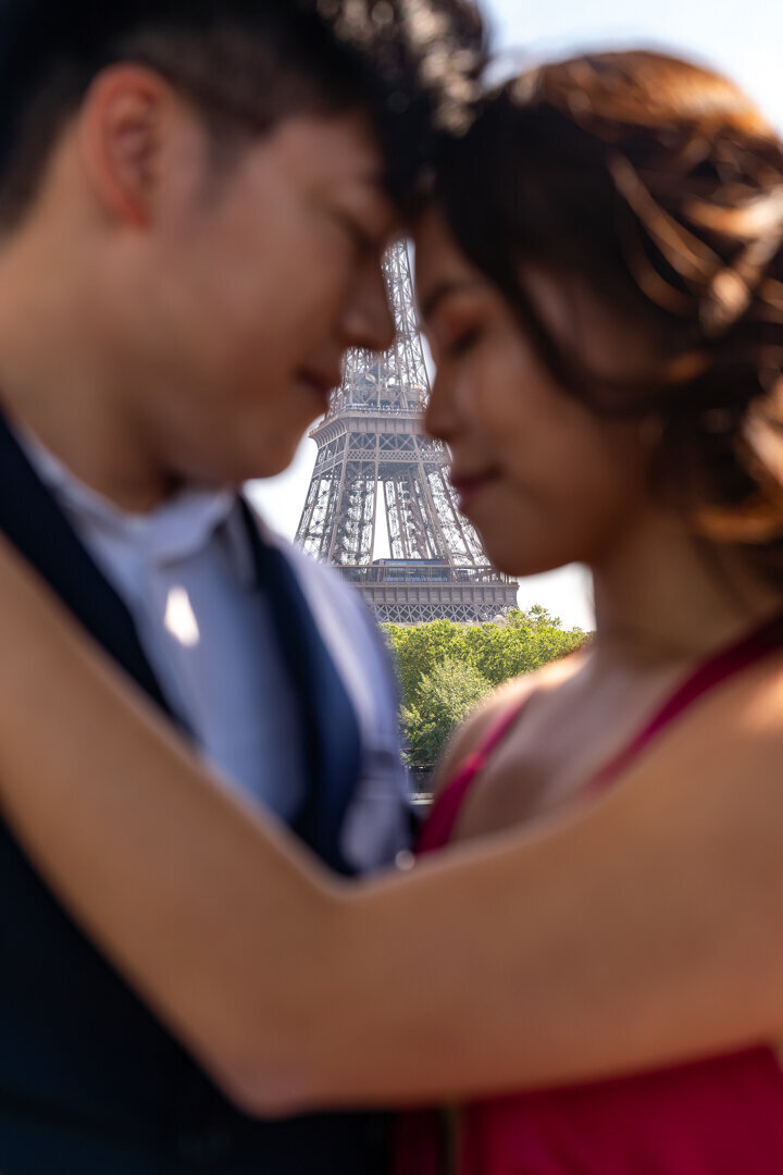Artistic couple portrait Paris, blurred forehead touch, centered Eiffel Tower composition
