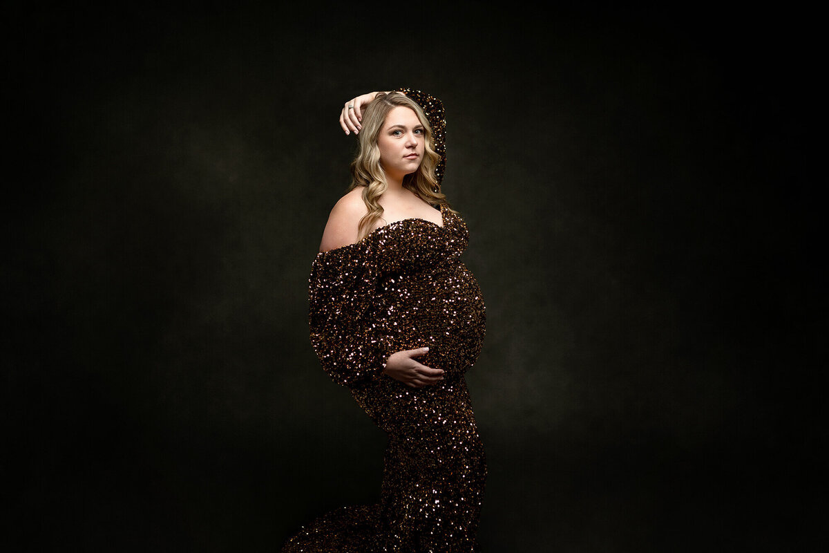 Beautiful mommy-to-be wearing a gold sequin gown during her maternity photoshoot.