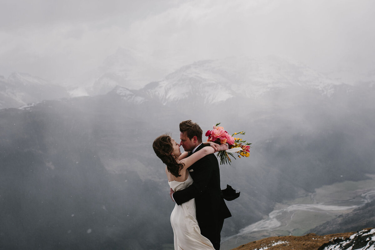 The Vase Floral Co - mountain wedding in Queenstown bride holds colourful bouquet