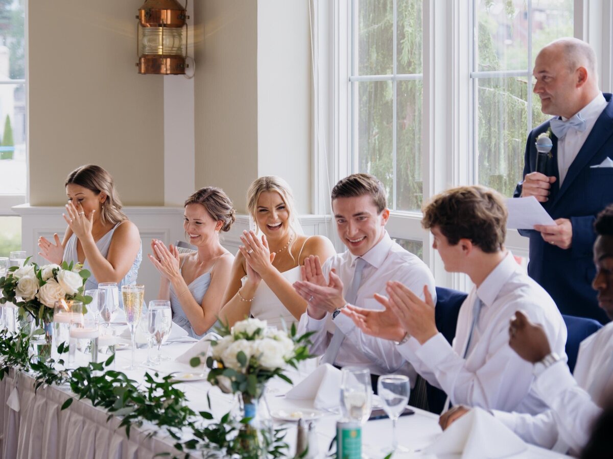 Couple clapping at their Cleveland Yachting Club wedding reception