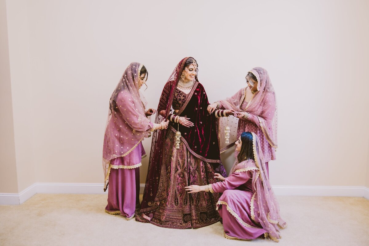 Bridesmaids helping the sikh bride get ready before the wedding ceremony at bridgewater nj gurudwara