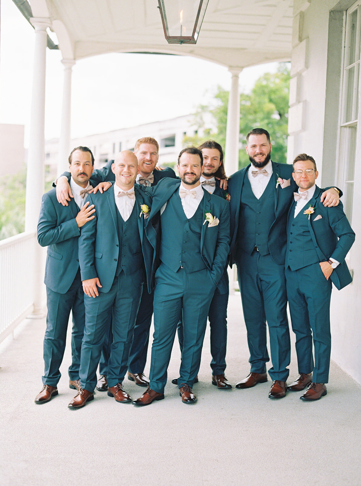 Groom and groomsmen in blue on the porch at Gadsden House.