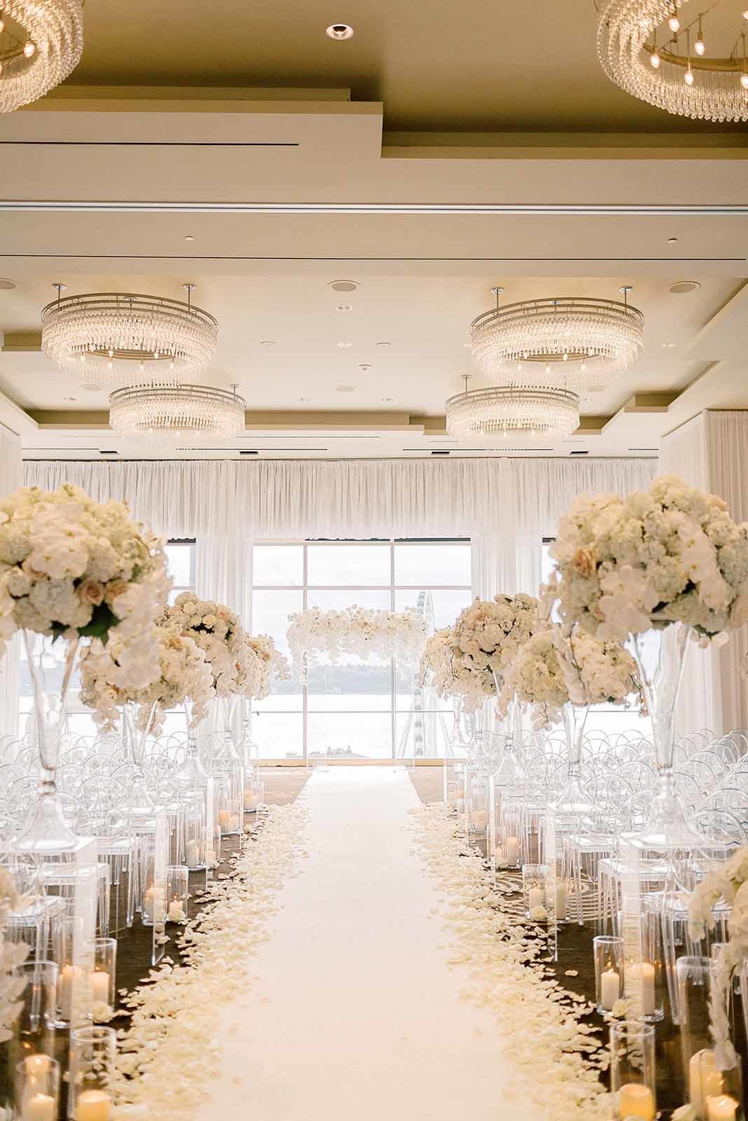 all white wedding ceremony with large orchid arrangememts, and a large wedding arbor covered in white orchids at Four Seasons Seattle, designed by Flora Nova Design
