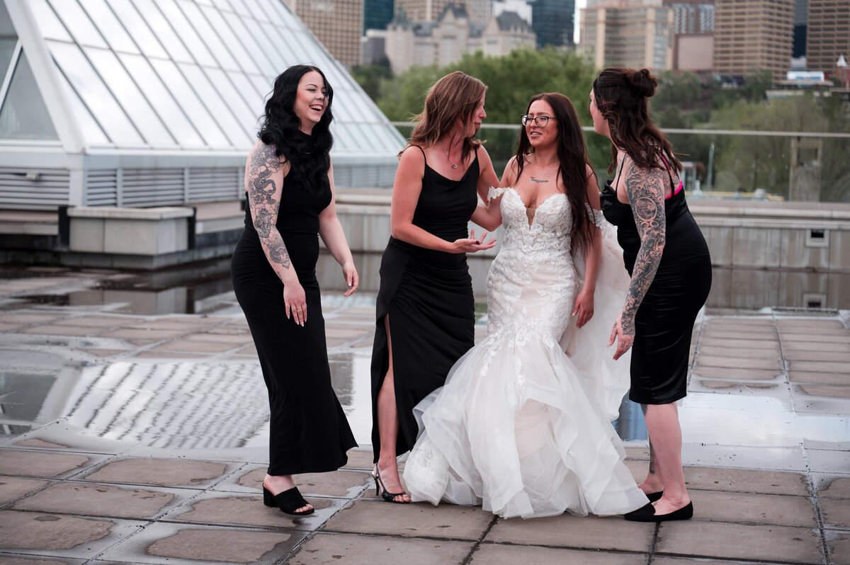 Bride and bridesmaids partying and celebrating the wedding outside of the Muttart Conservatory in Edmonton, Alberta