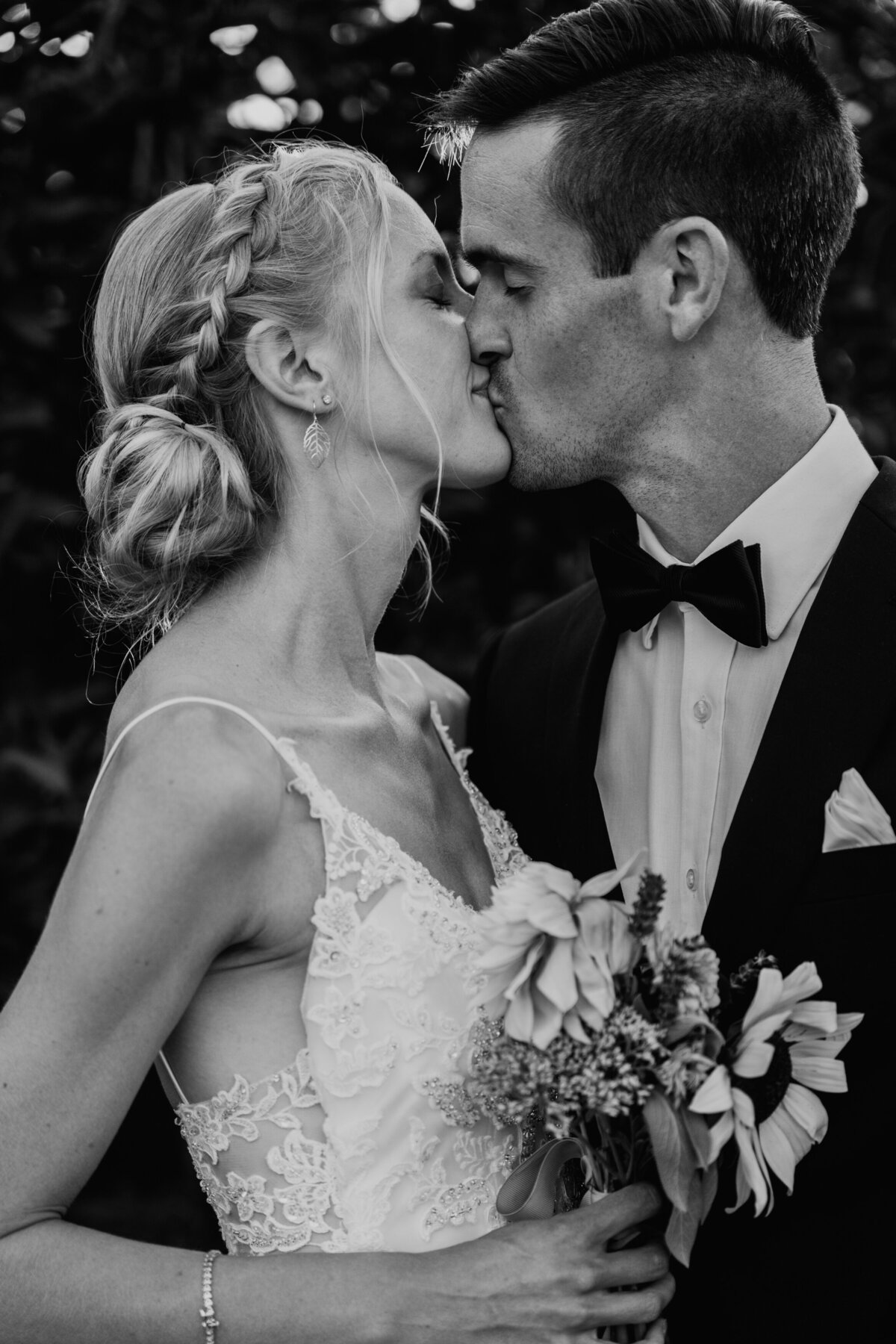 Bride and groom kissing in garden during golden hour