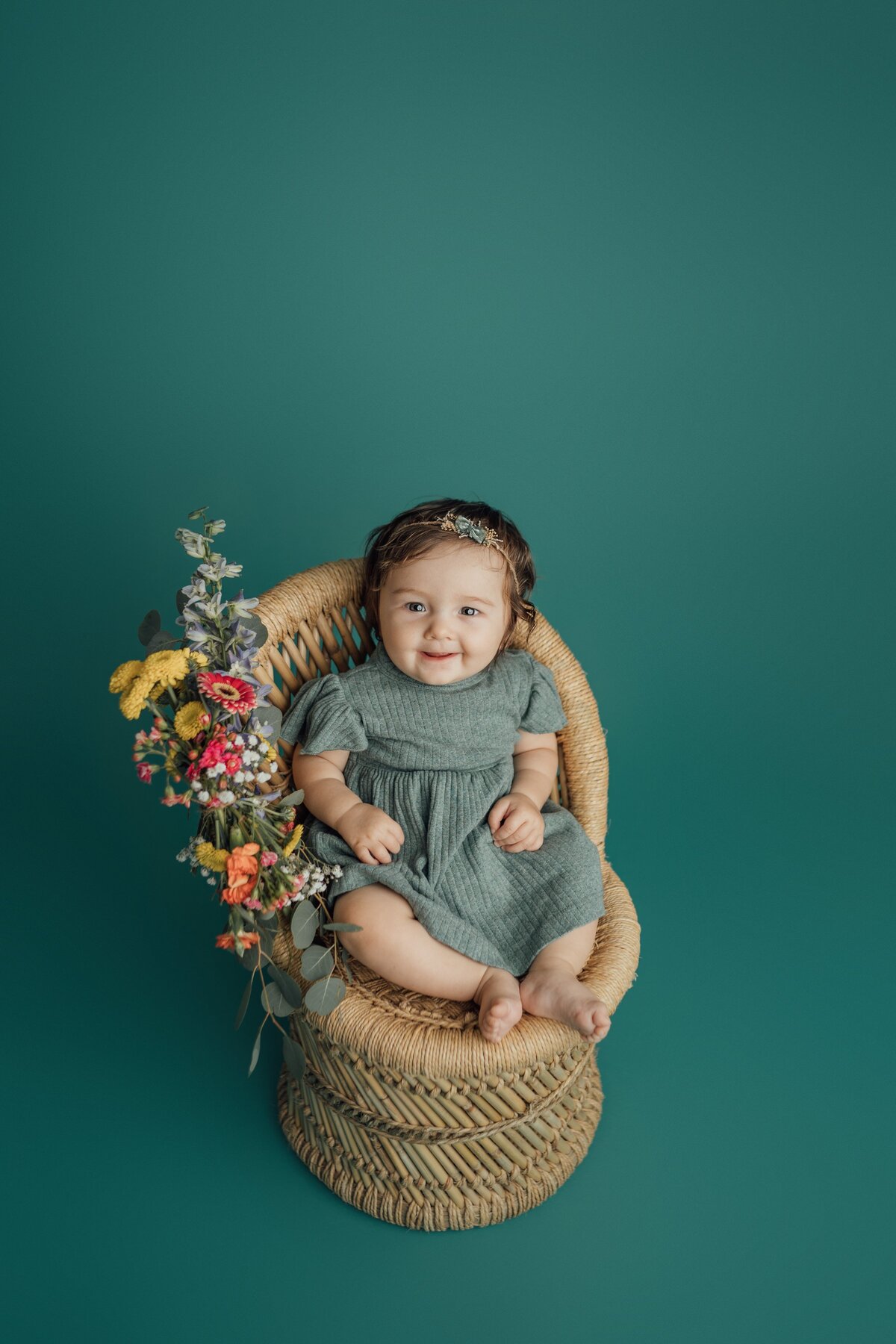 girl on teal on a rattan chair at st. pete studio