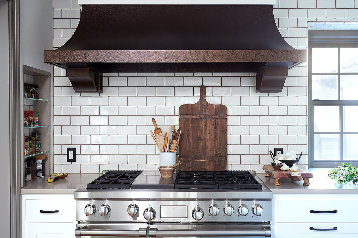 stainless stove top with dark stained range hood