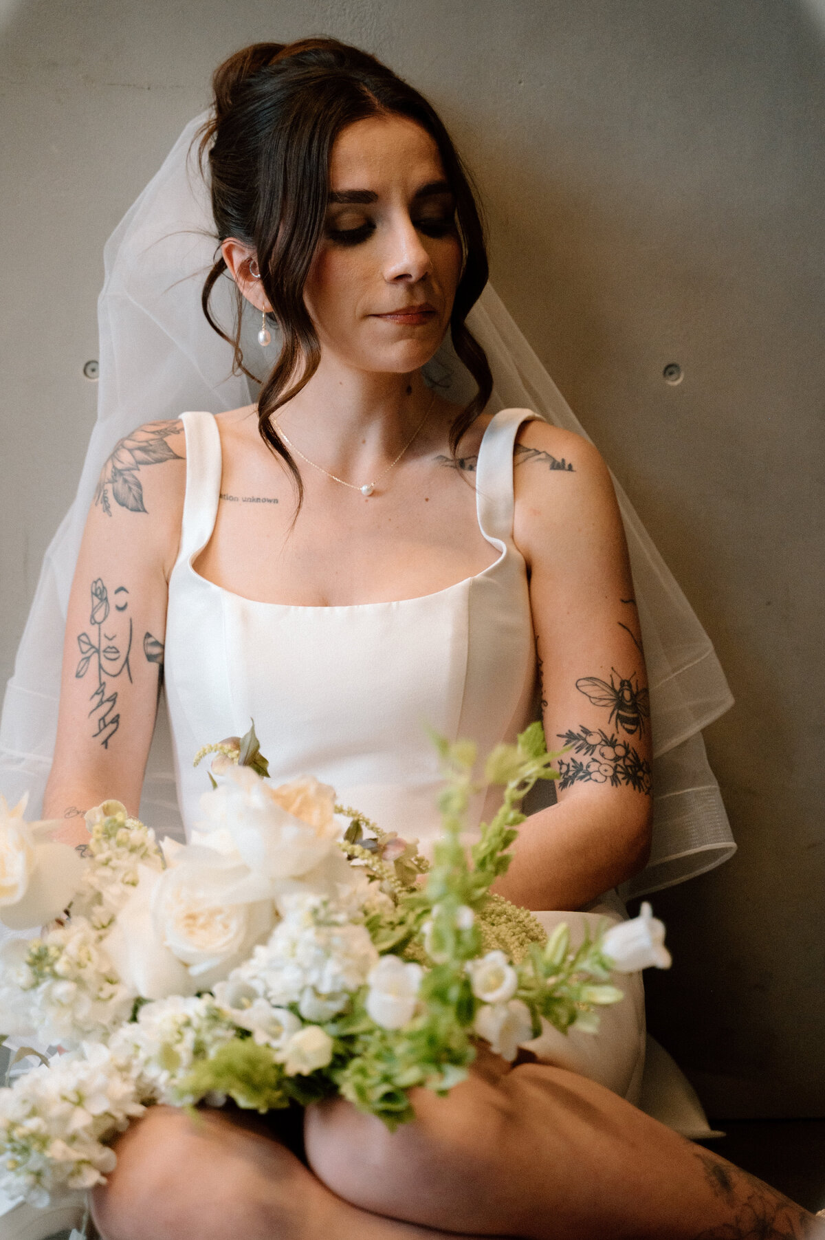 Bride seated peacefully with bouquet in editorial bridal portrait at Banff wedding venue.