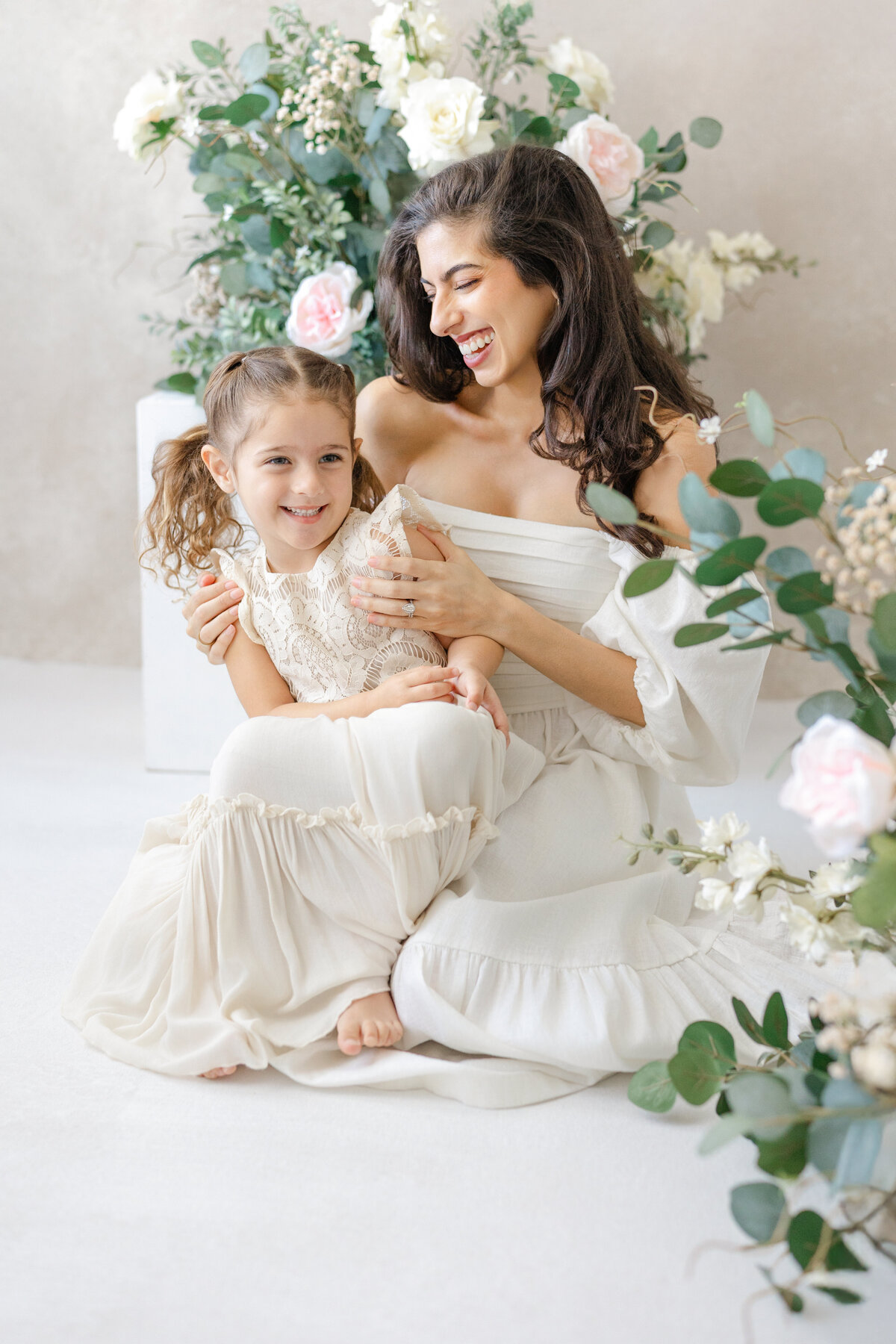 Joyful Tampa motherhood portrait of mom and daughter laughing together in soft natural light studio