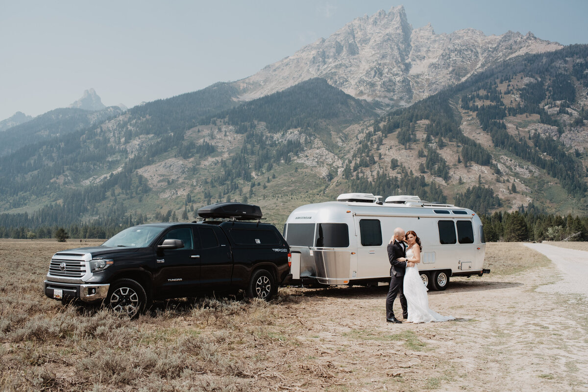Jackson Hole photographers capture bride and groom kissing in front of rv