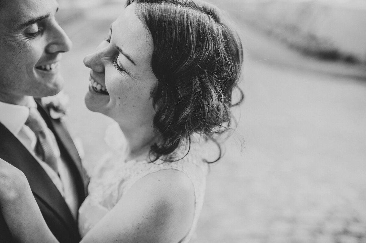 A couple who got married in France at a chateau looking at each other in a romantic photography on their french wedding day.