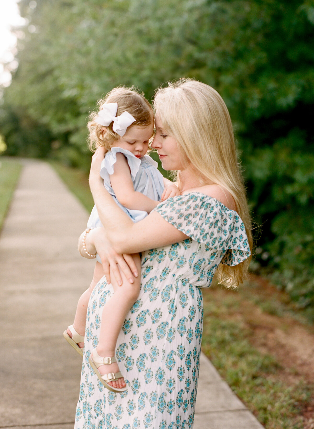Toddler sits on her mom's belly. Image by Raleigh maternity photographer A.J. Dunlap Photography.