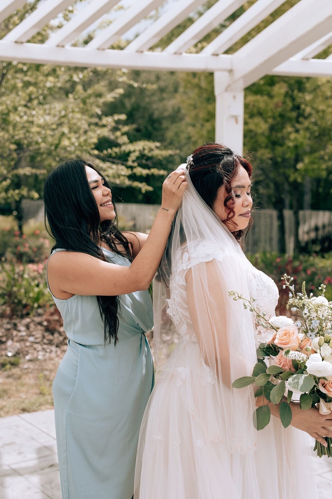 brides maid of honor putting on her veil