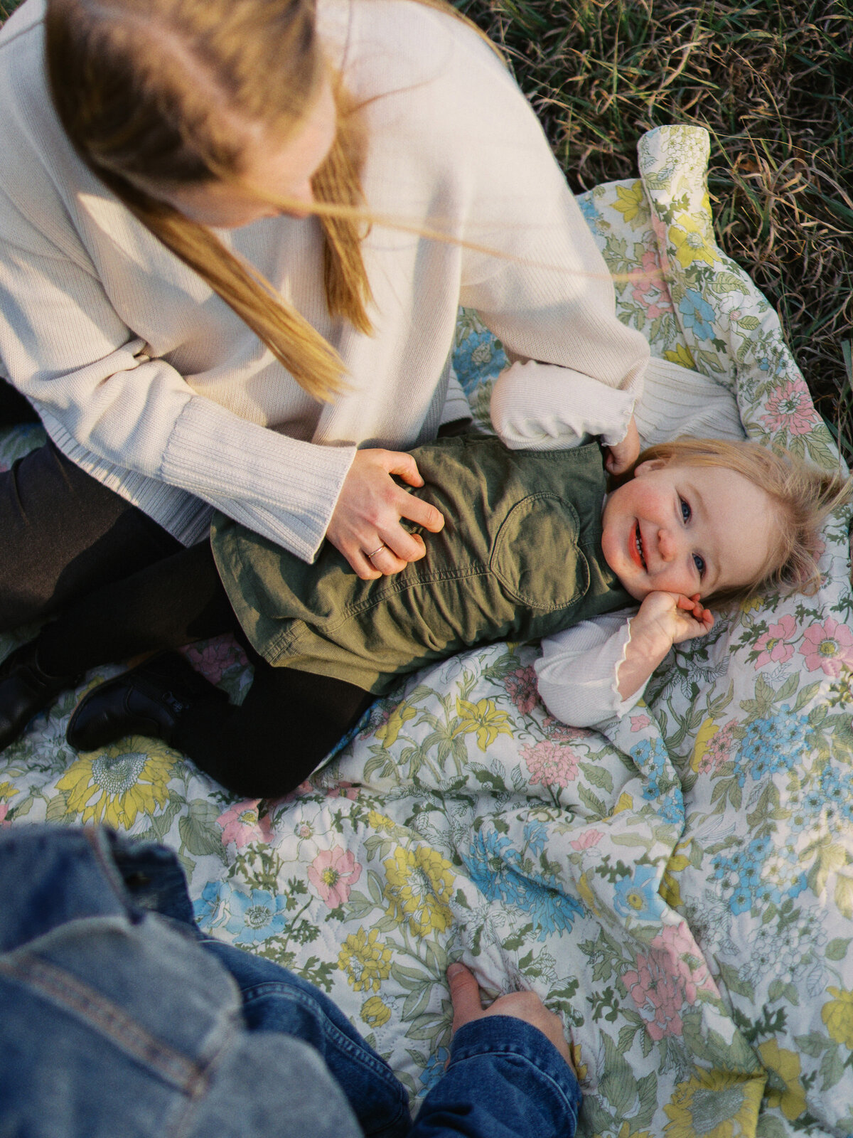 mother-tickling-baby-on-blanket