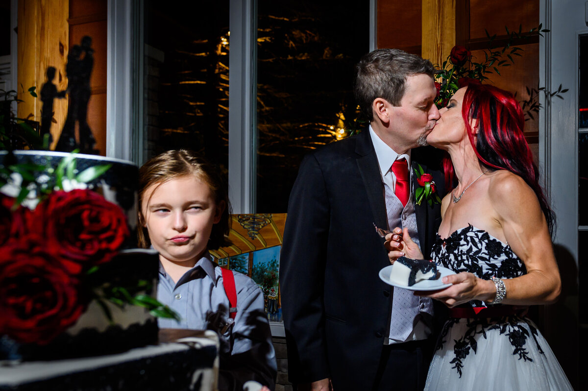 A young boy makes a face while the bride and groom kiss