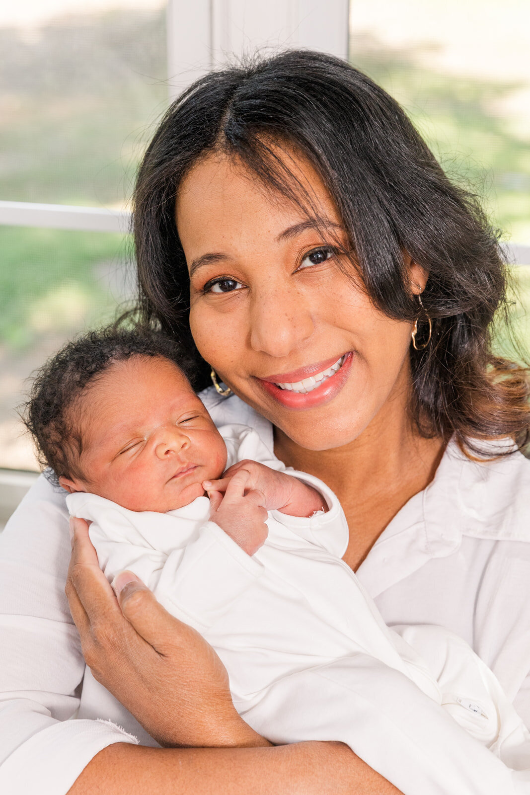 mom holding newborn  close up to her face both wearing white outfits Laure Photography Atlanta family and newborn photographer