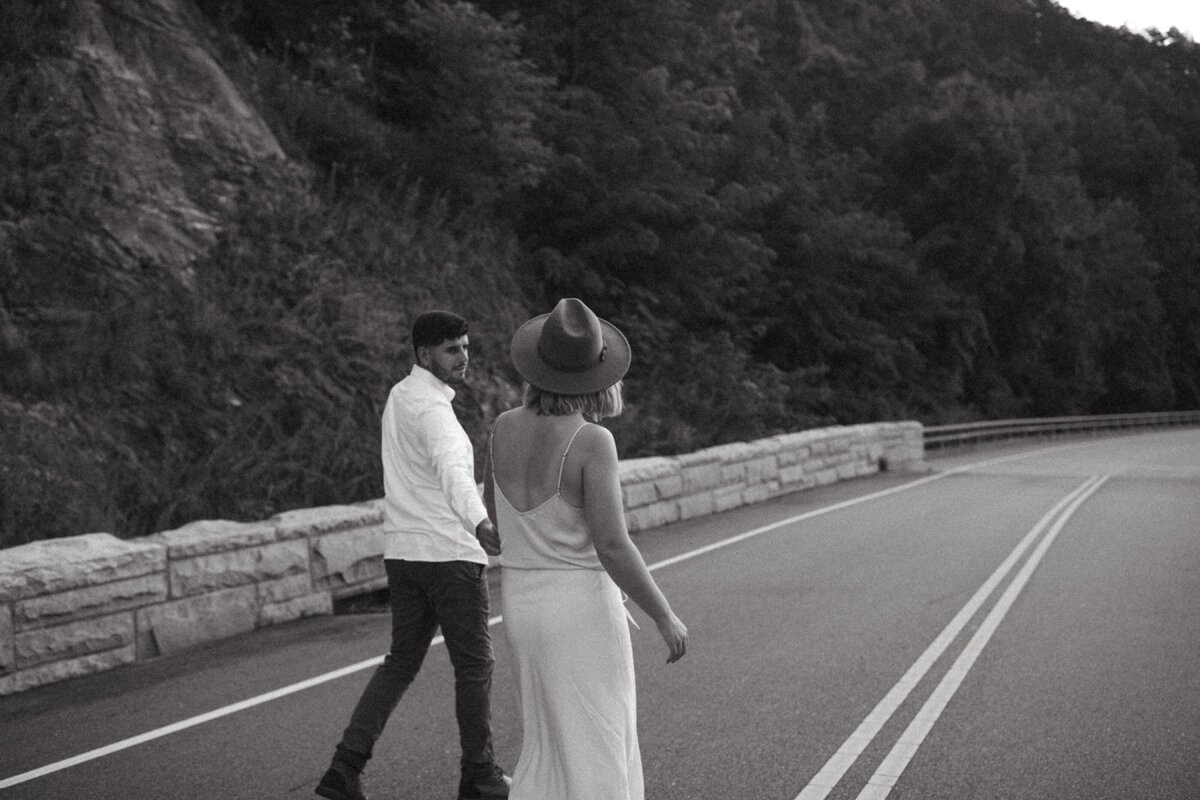 couple-walking-hand-in-hand-on-mountain-road