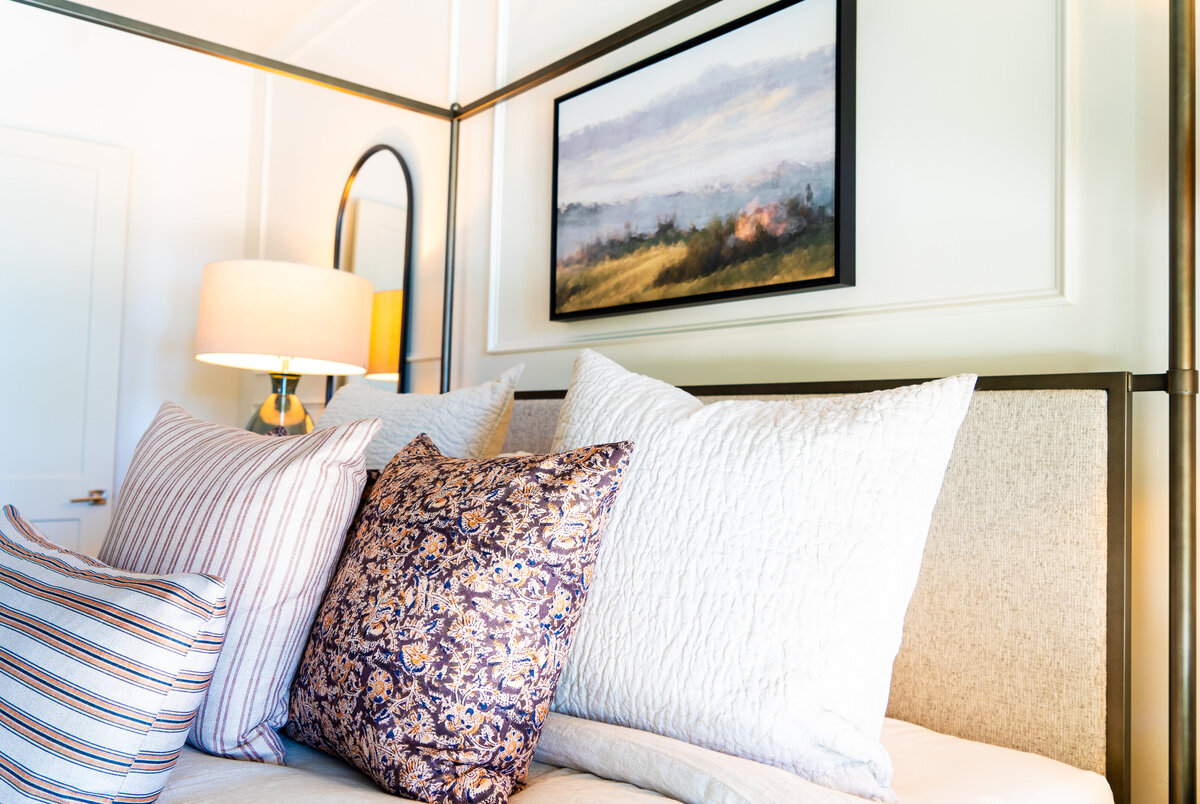 luxury bedroom with white dresser white sitting chiar and bed with blue blanket