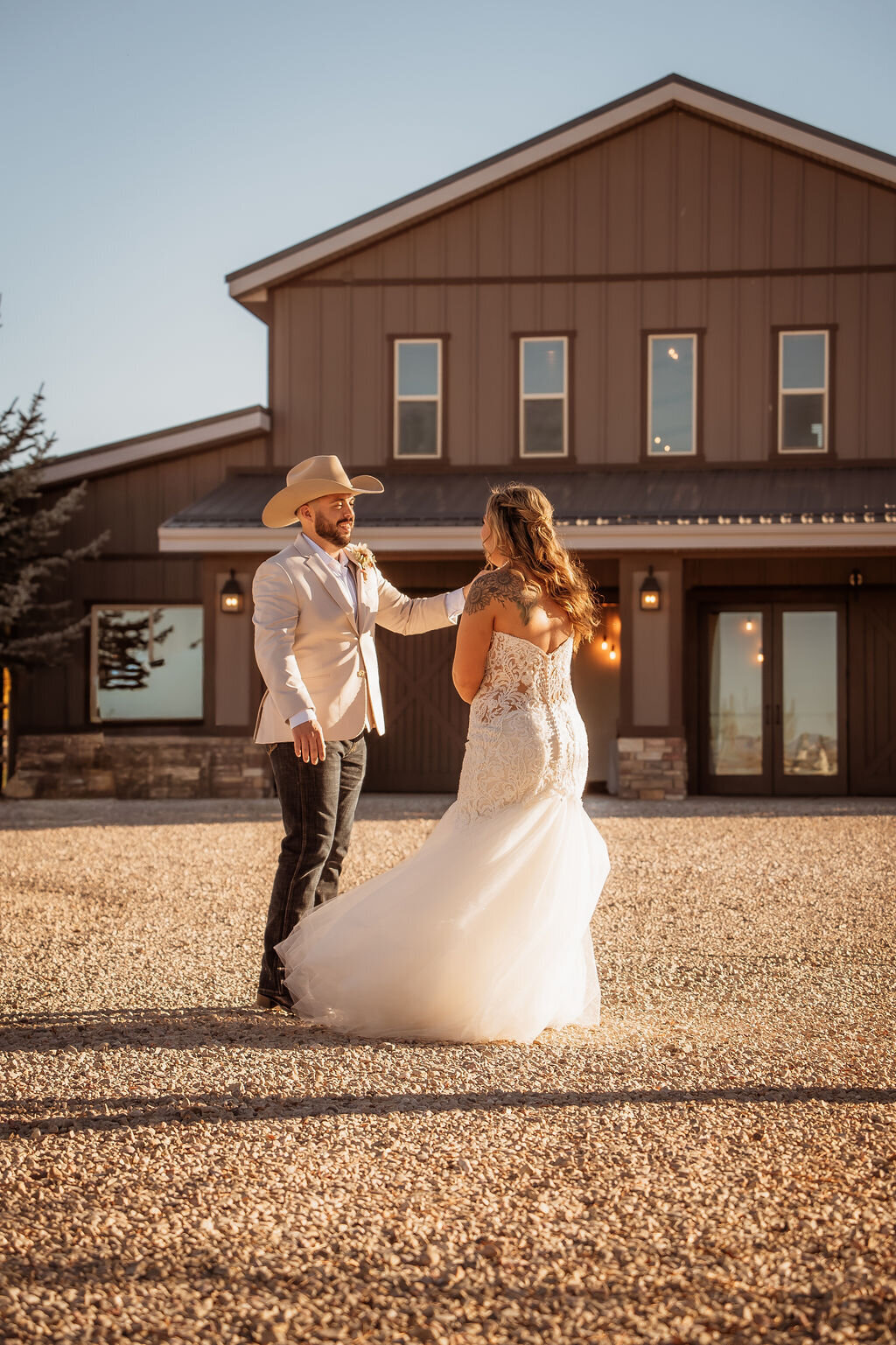 Couple dancing on the gravel drive in front of the barn