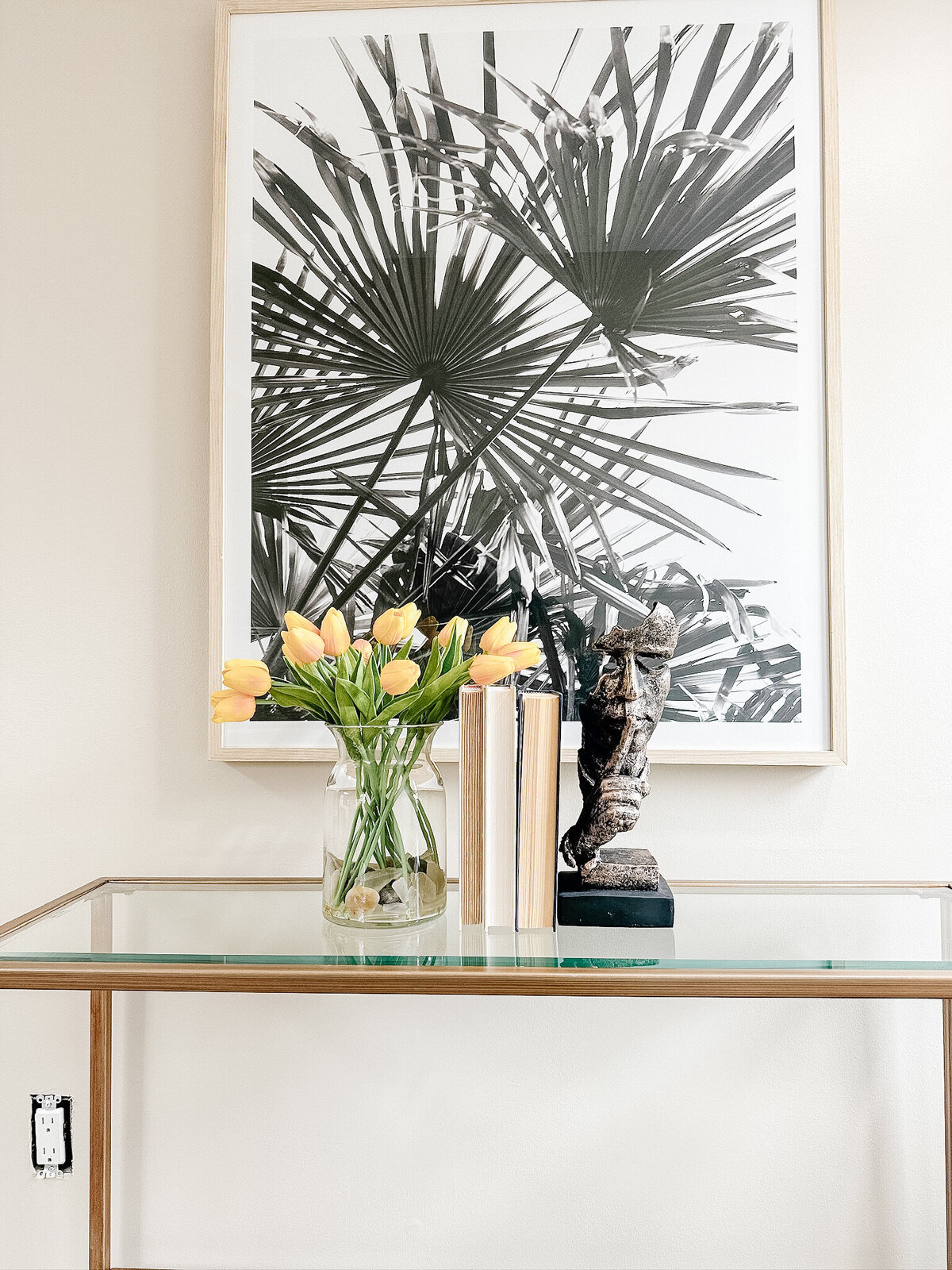 Entry table with abstract art, flowers, and accessories