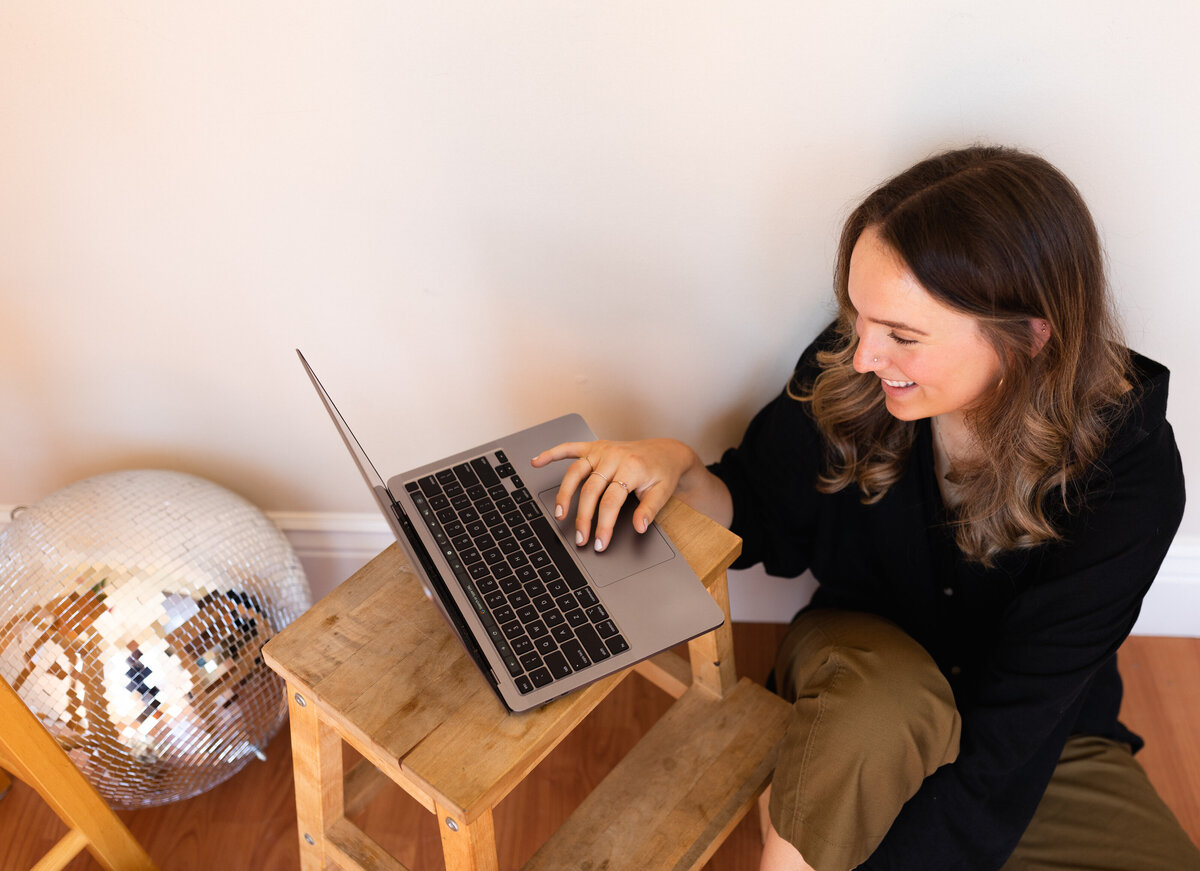 A woman working on freelance website design on her computer.