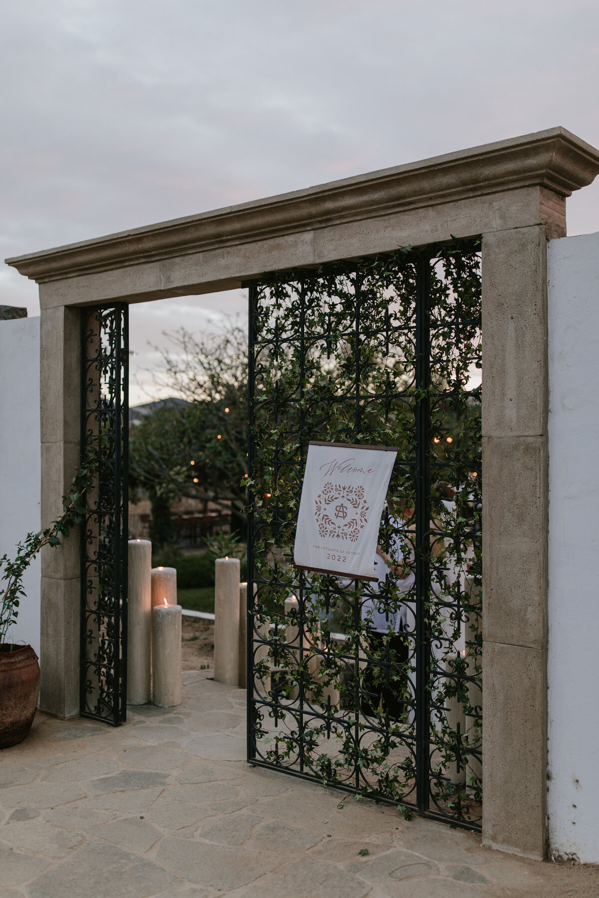 entrance to private estate showing custom stationery welcoming guests to a  High-end wedding Mexico