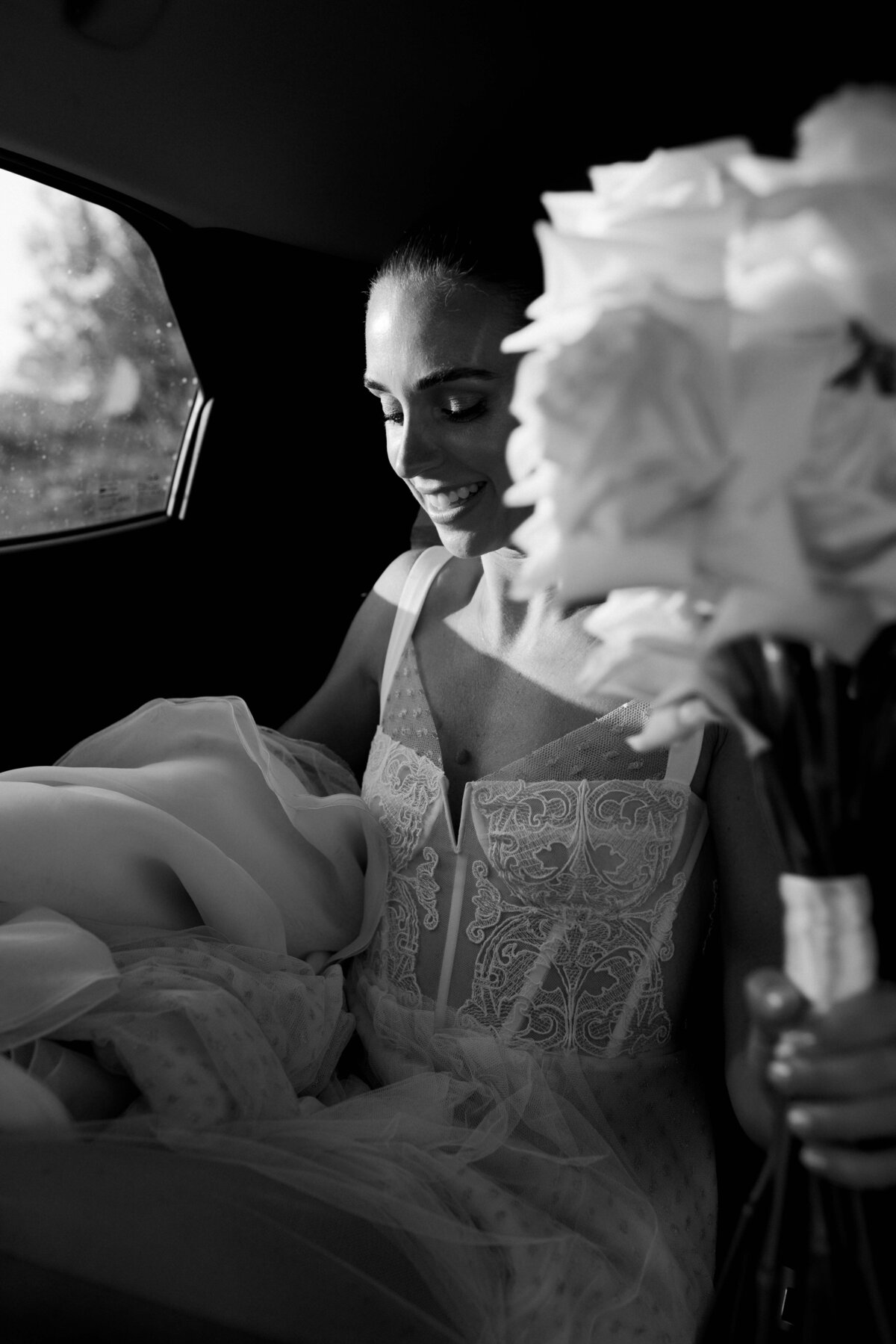 bride in couture wedding gown arriving to wedding in car