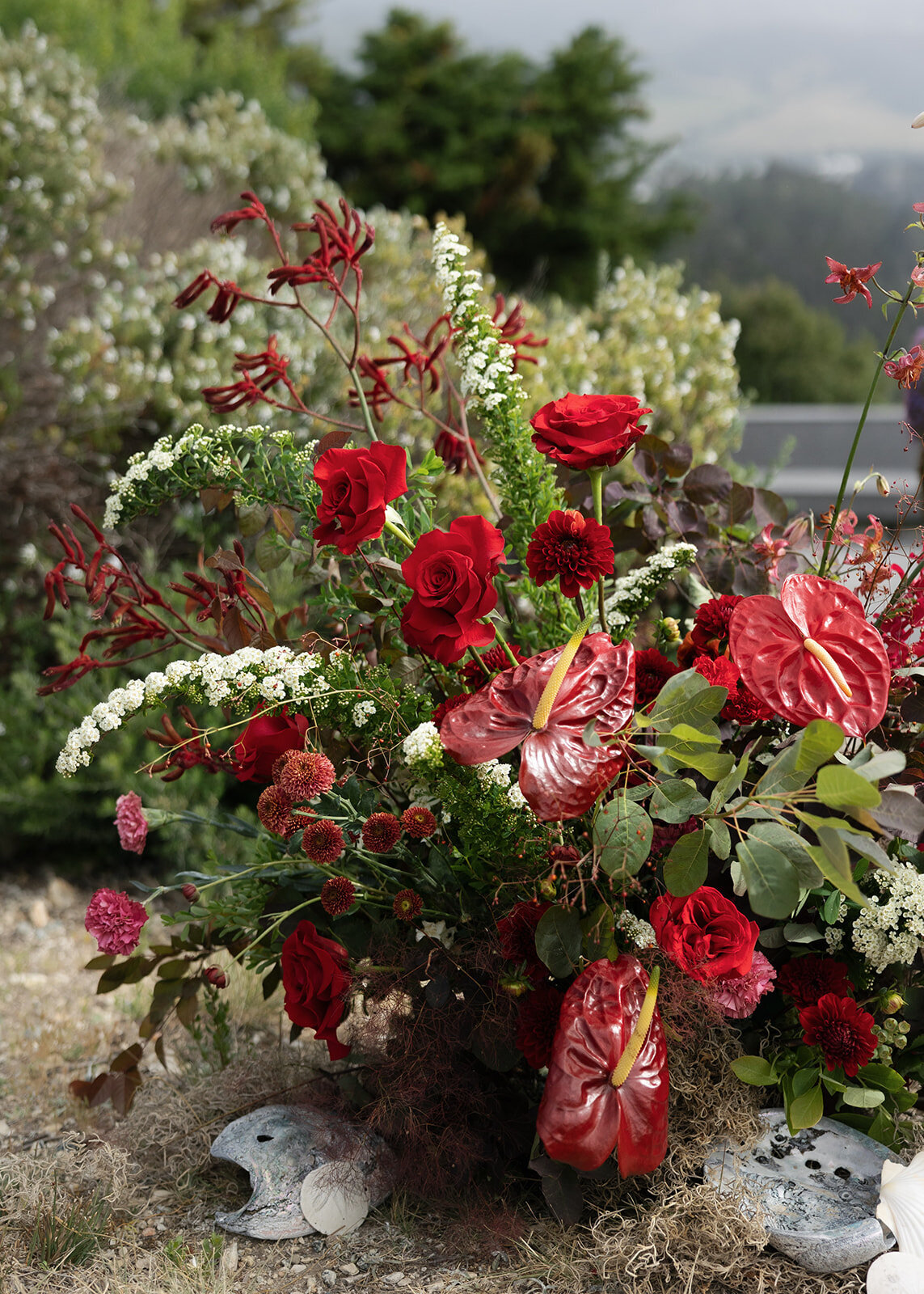 Lush red and green wedding floral arrangement outdoors