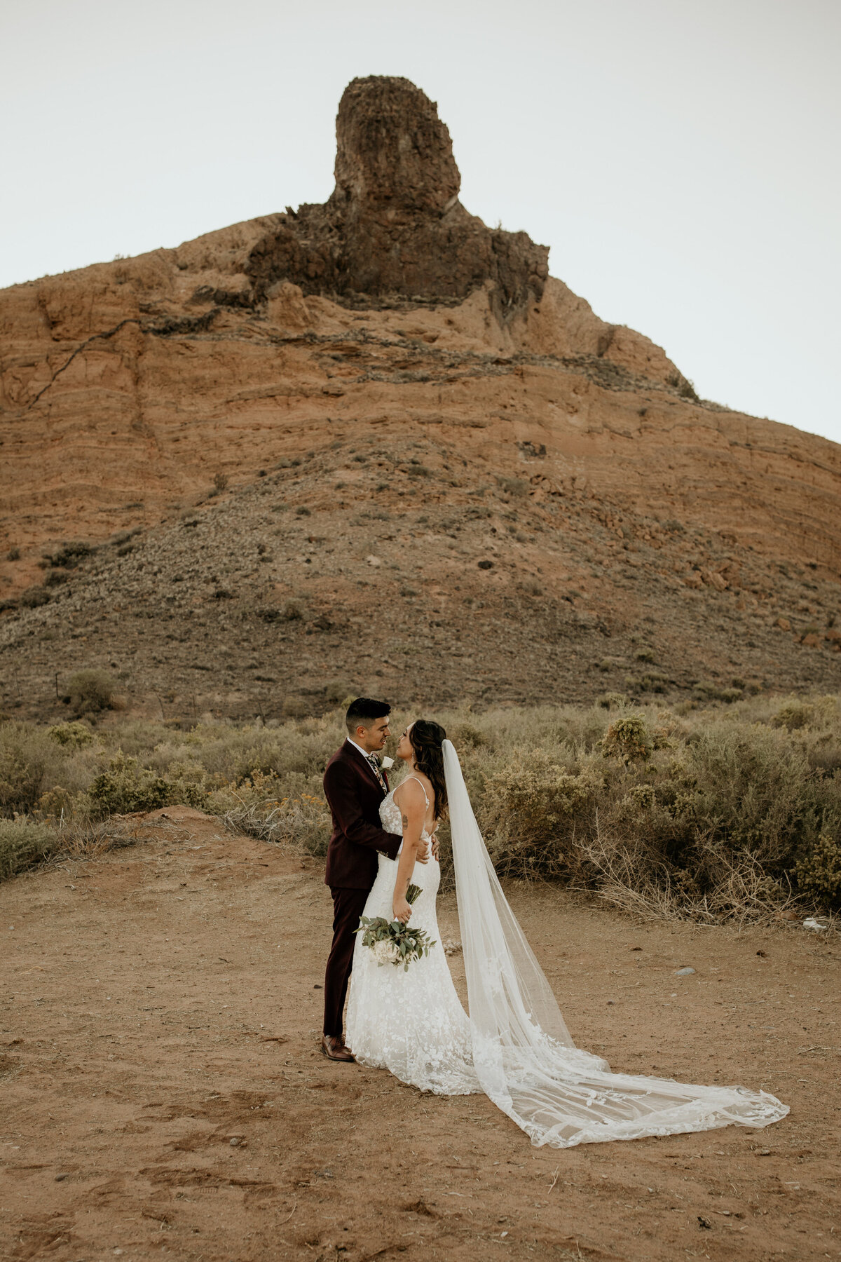 bride and groom holding each other in the desert in Albuquerque