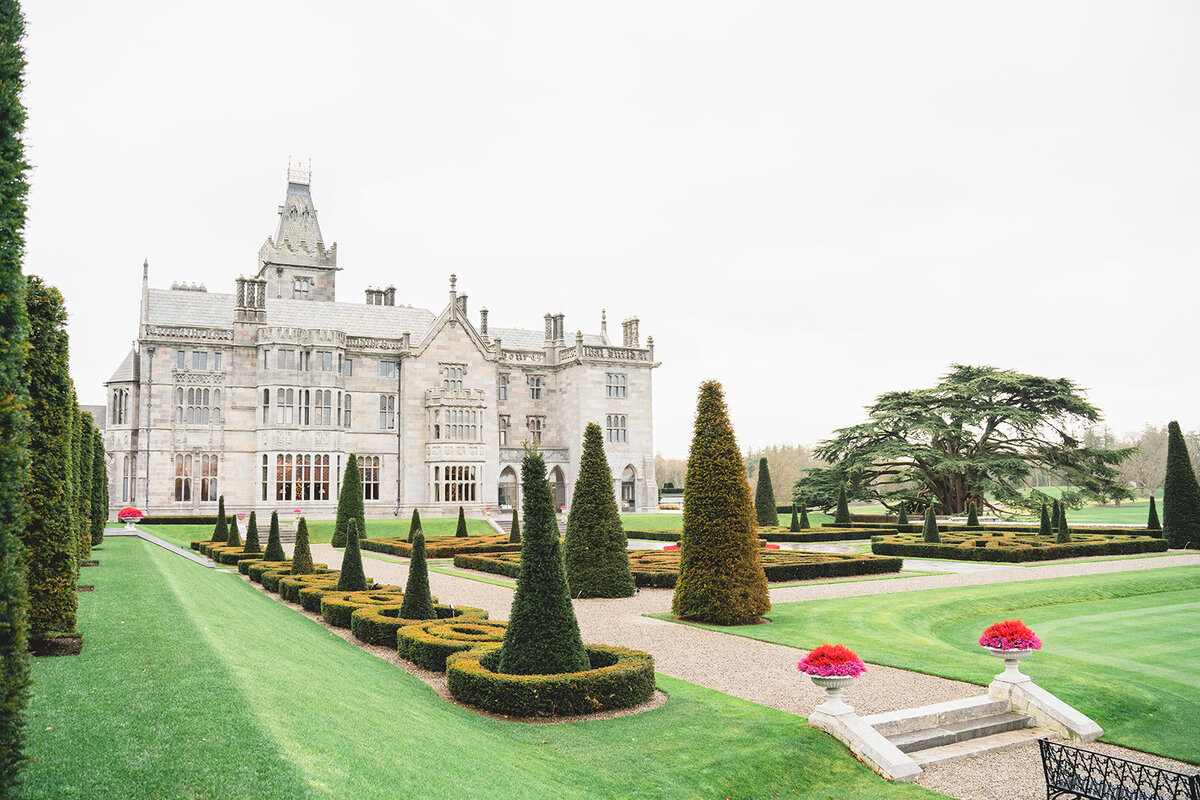 A photograph of the exterior of  adare manor taken from the rear in the gardens of this beautiful luxury wedding venue