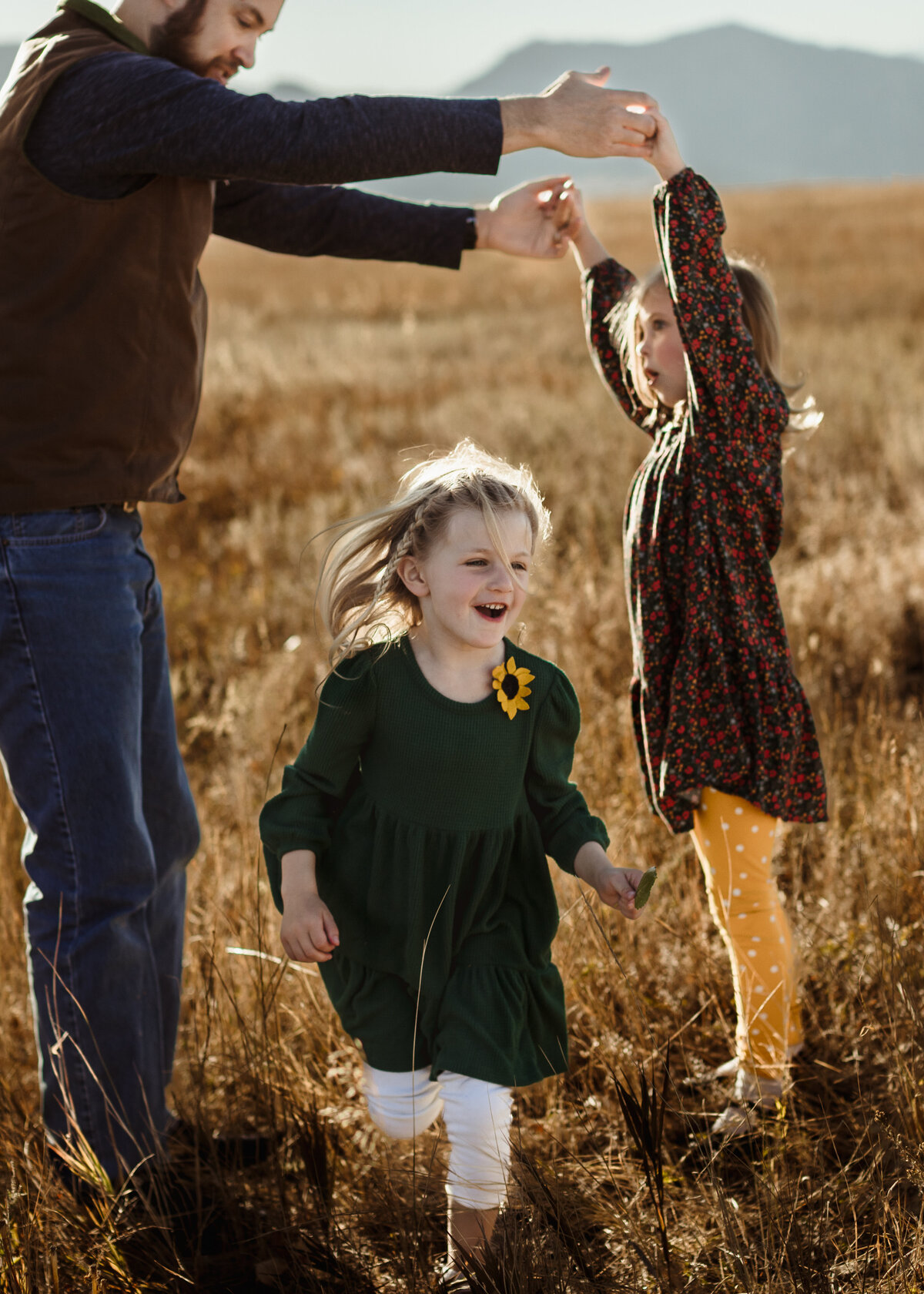 family plays in a field during fall family photos