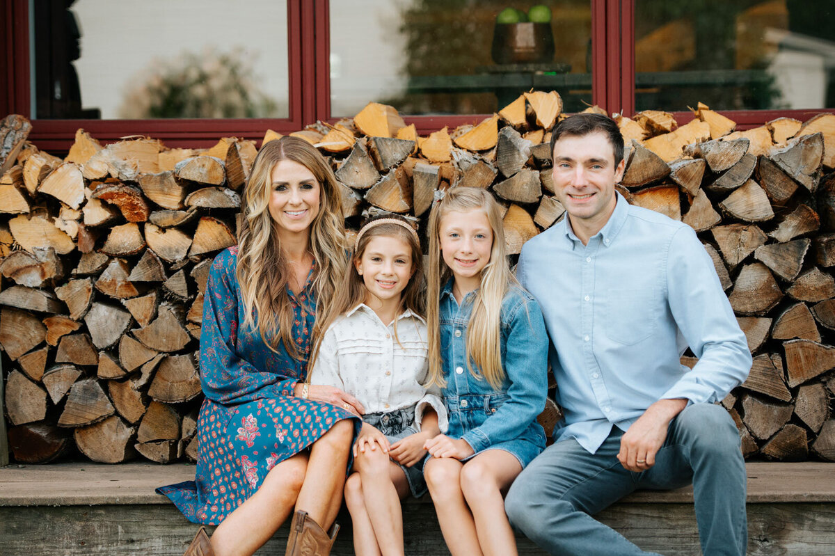 vermont family in front of woodpile