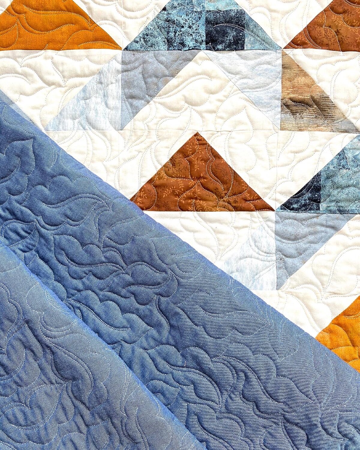oak-ish leaves on a blue, brown and white quilt.