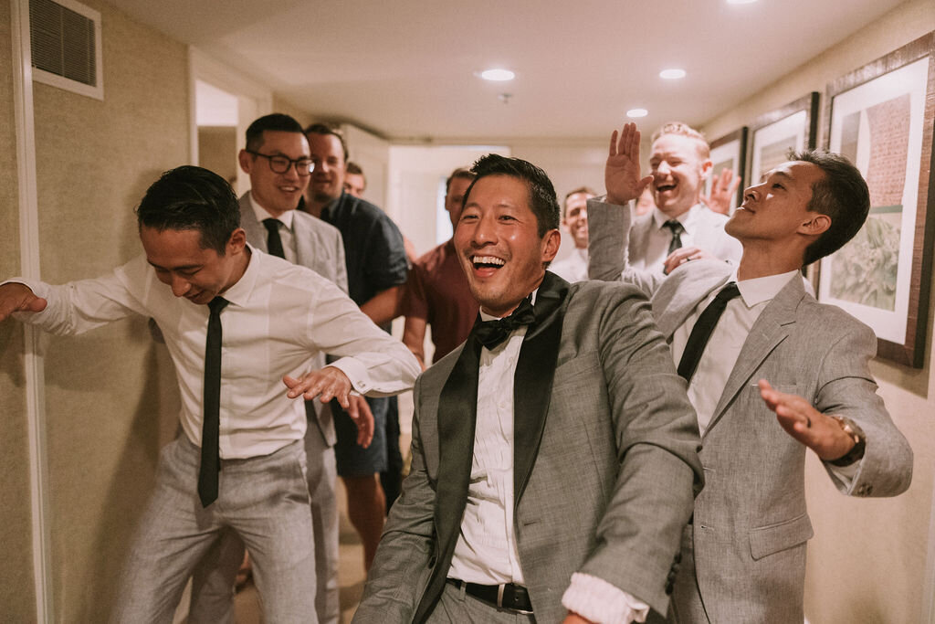 Groom and groomsmen performing a song and dance for Chinese wedding games at Four Seasons Oahu
