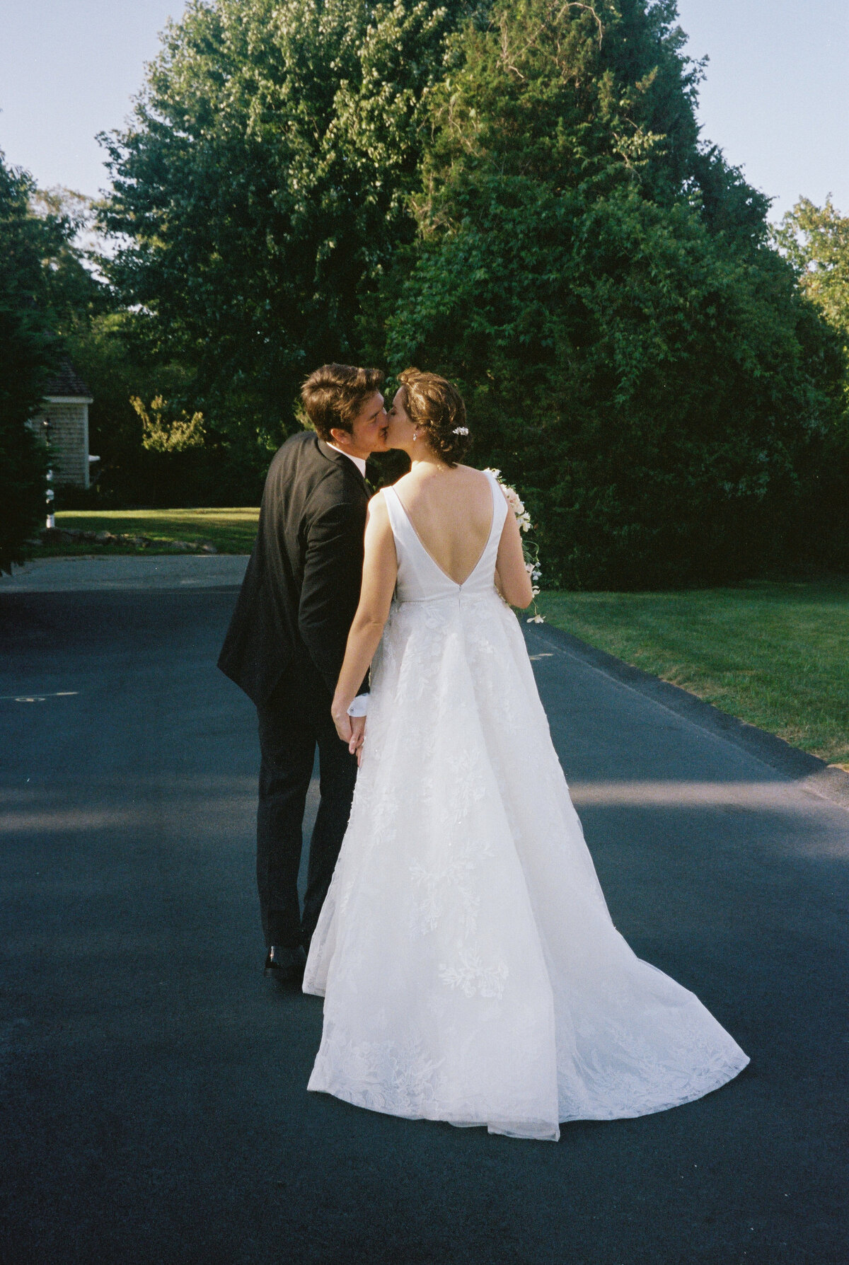 bride and groom kissing while walking
