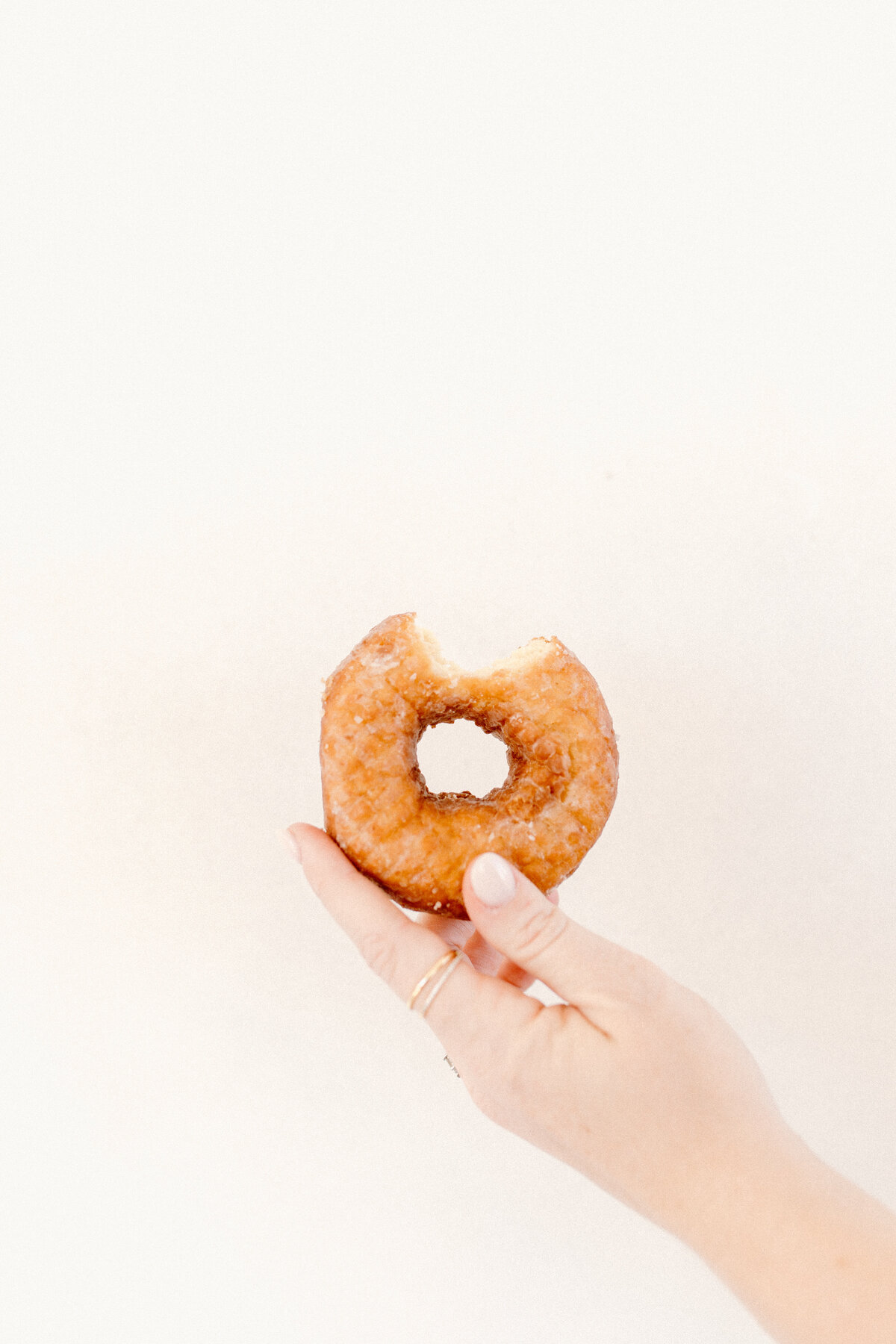 one bite donut in woman's hand