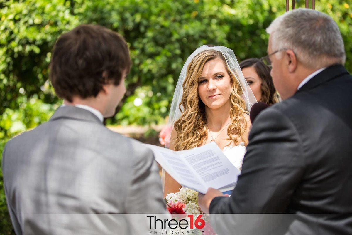 Bride looks at Officiant as he reads the marriage vows