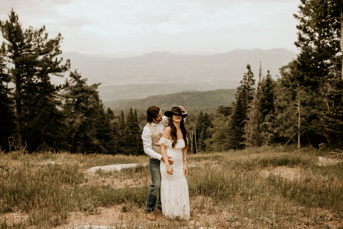 groom holding bride from bahind at Sandia Peak in Albuquerque