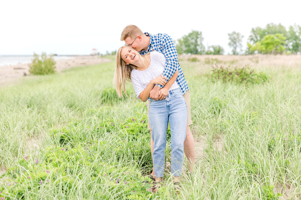 Light and airy beach engagement session with lighthouse summer at Mentor Headlands Beach