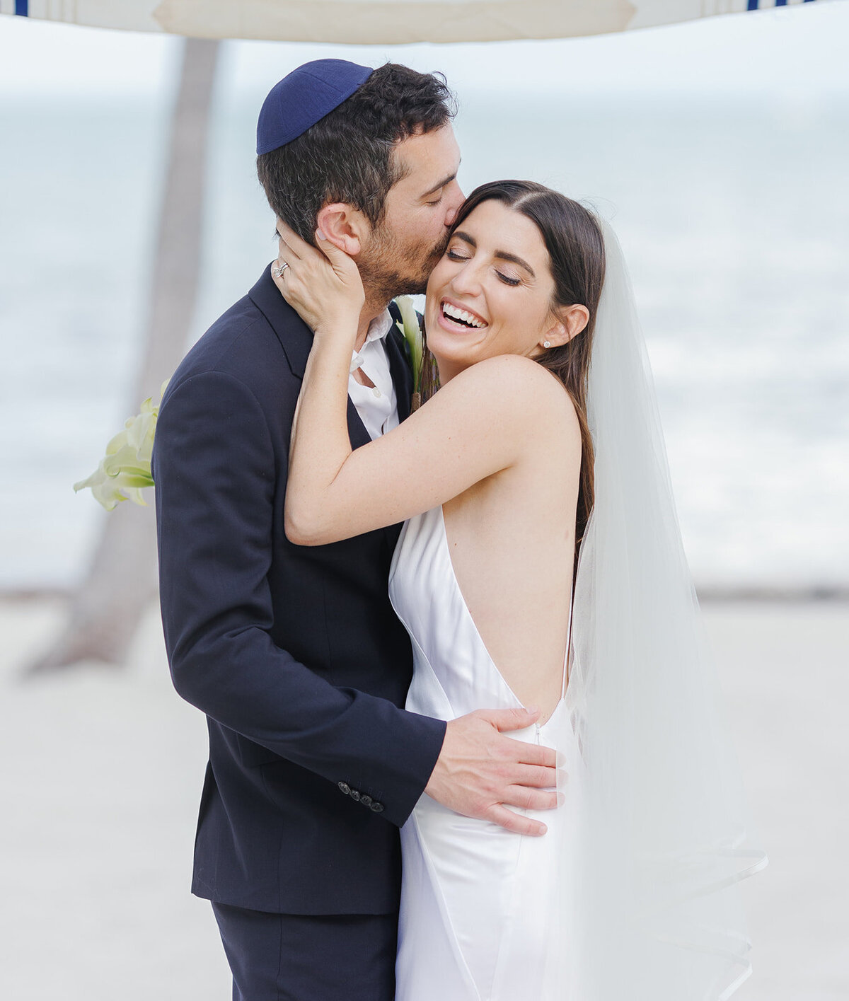 Evan lovingly hugs Minette as they celebrate their wedding day. Florida Keys micro wedding captured by Claudia Amalia Wedding Photography.