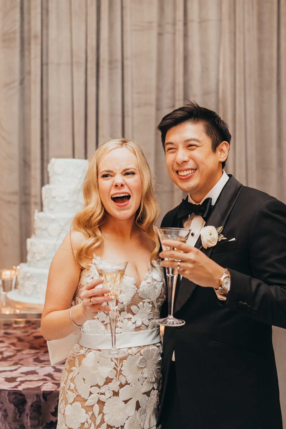 bride and groom laugh after sharing a toast