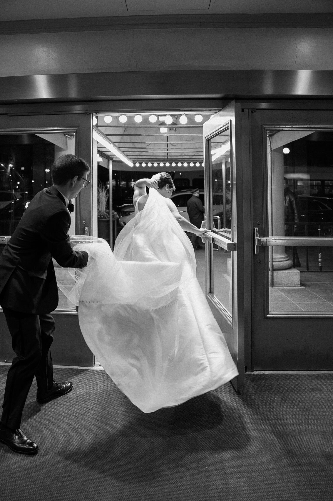 A black and white picture of the bride and groom walking outside after their wedding ceremony. Fairmont Copley Plaza Wedding.