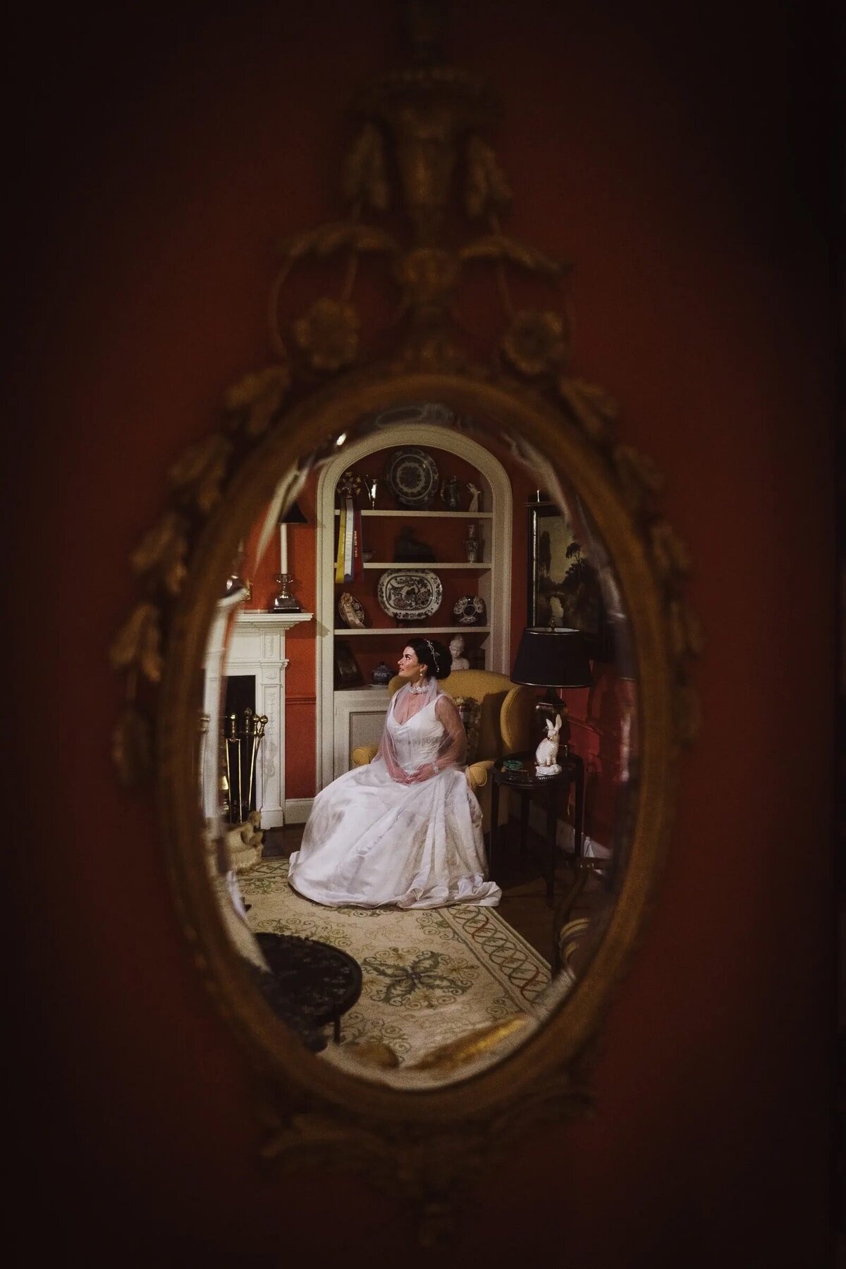 The reflection of a bride sitting in a chair in a mirror