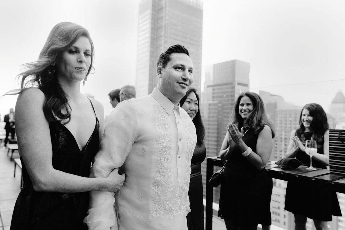 The groom is with a girl dressed in black in The Skylark, New York. Wedding Image by Jenny Fu Studio
