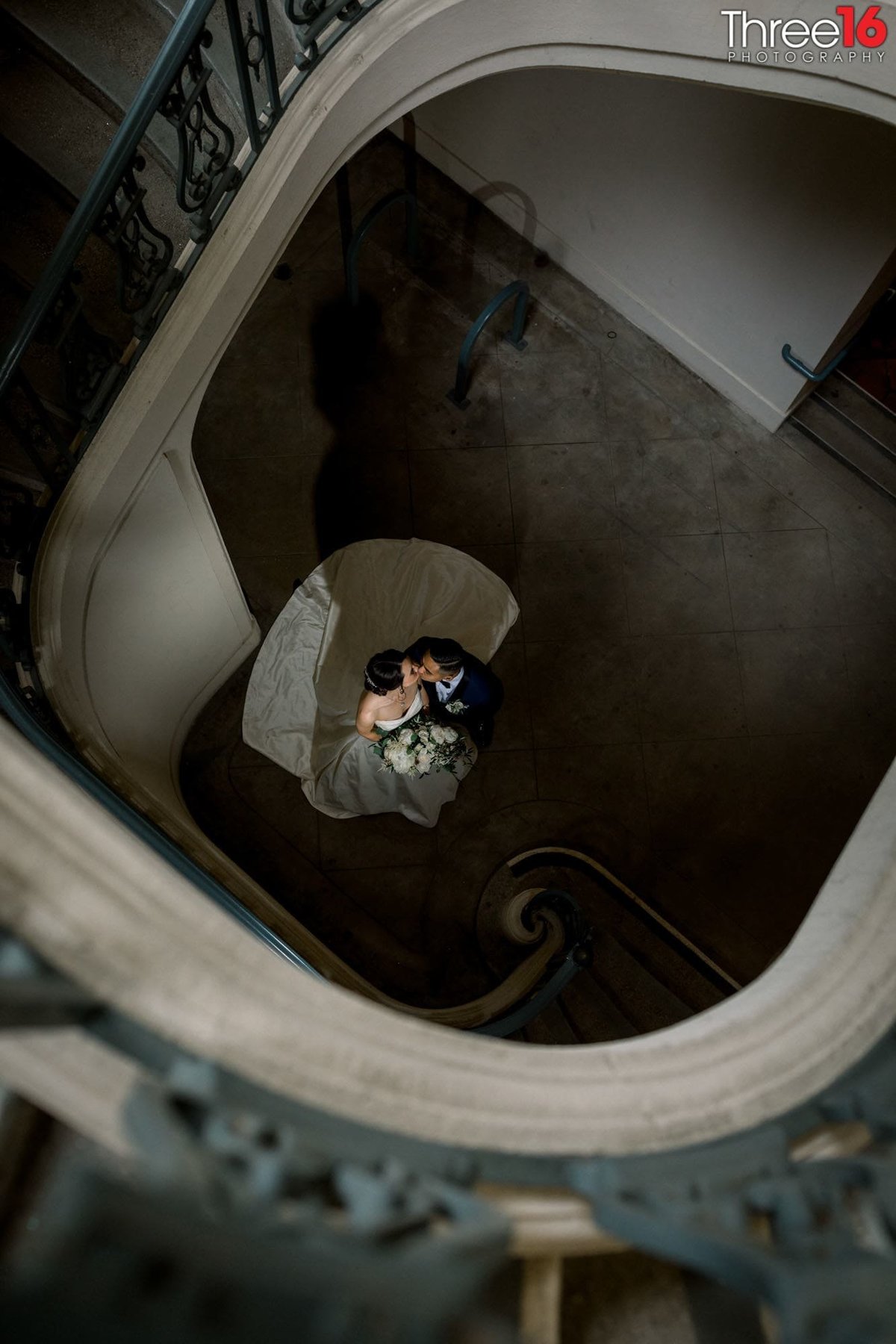 Bride and Groom share an intimate moment at the bottom of the spiral stairwell