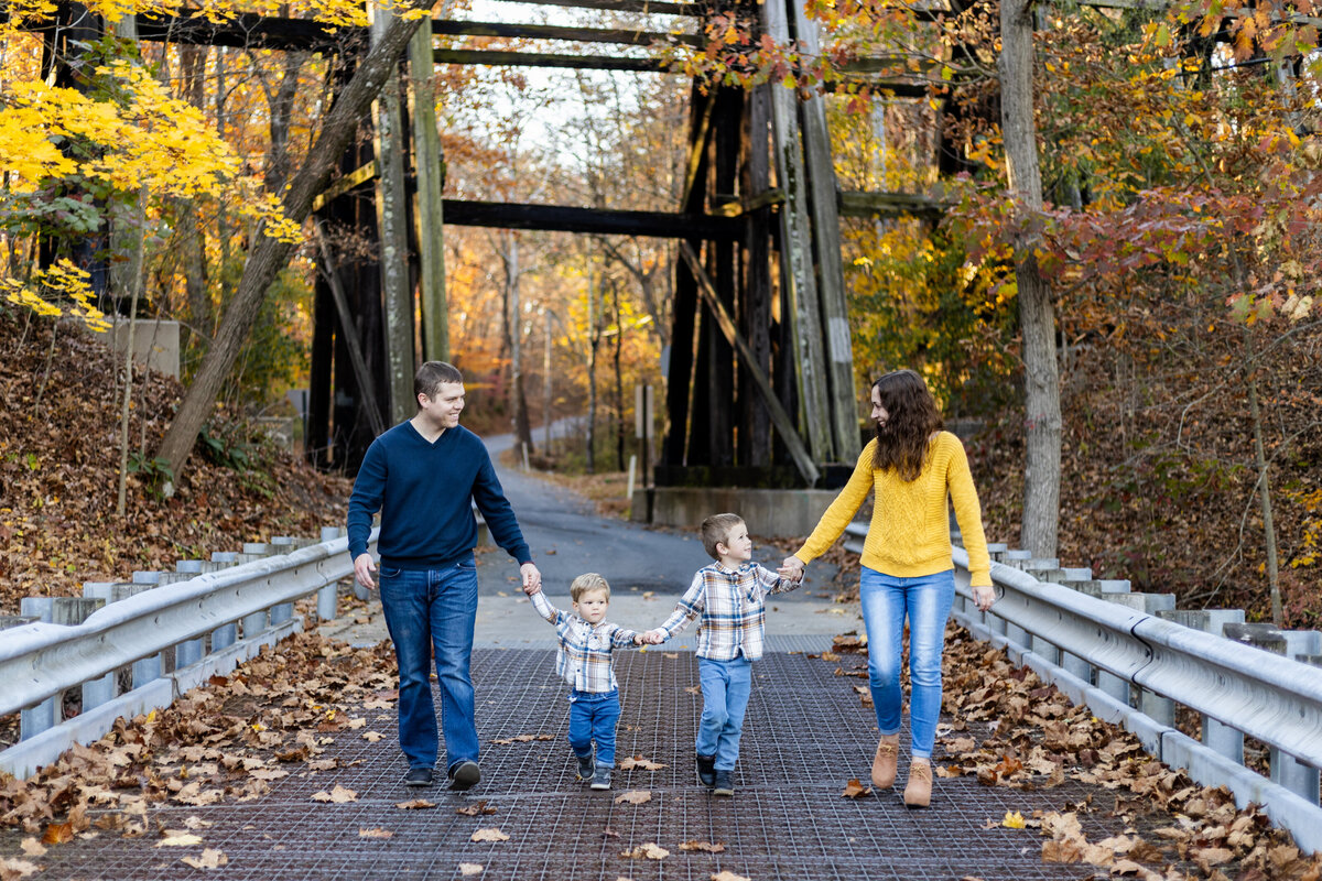 Photo of family holding hands and walking on bridge at Ironstone Park in Boyertown PA