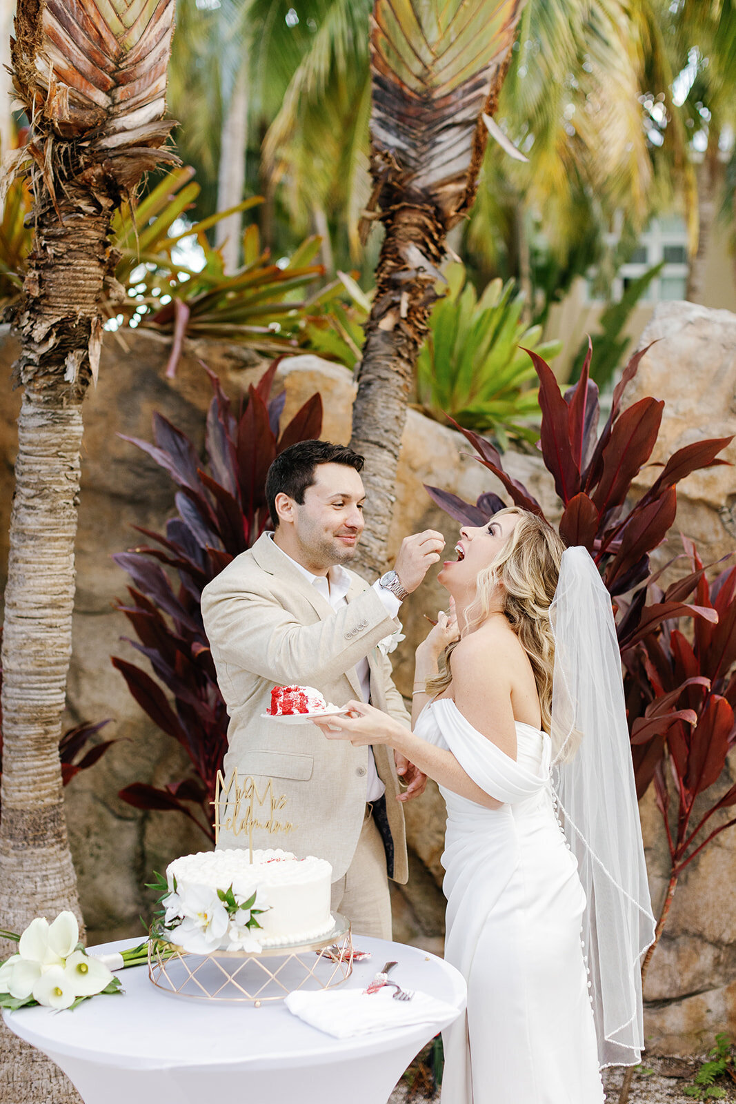 Monica and Austyn share a playful moment as they cut their wedding cake at their intimate Florida Keys wedding.